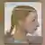 Cuadro titulado "Chica joven". Se ve una chica pintada de perfil con una diadema de perlas en la cabeza.