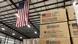 Boxes of humanitarian aid marked USAID in a warehouse with an American flag Boxes of humanitarian aid marked USAID in a warehouse with an American flag