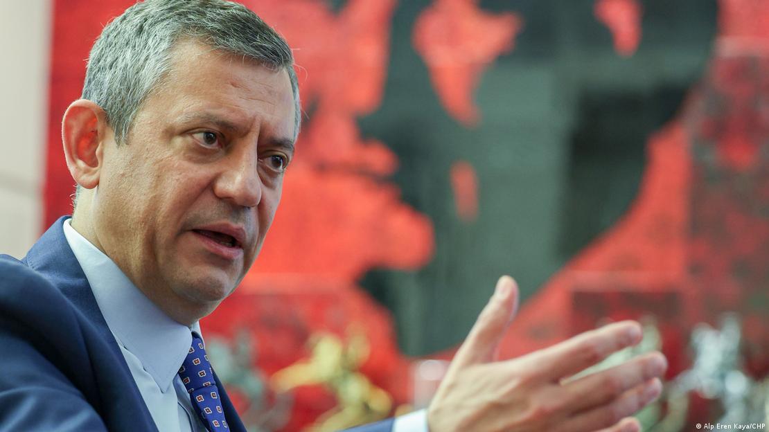 CHP Genel Başkanı Özgür Özel, kızgın bir ifade ile konuşurken bir elini havaya kaldırıyor 