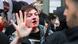 A person with reddish hair and a bloody nose holds up a bloodied hand while speaking to a police officer in Berlin A person with reddish hair and a bloody nose holds up a bloodied hand while speaking to a police officer in Berlin