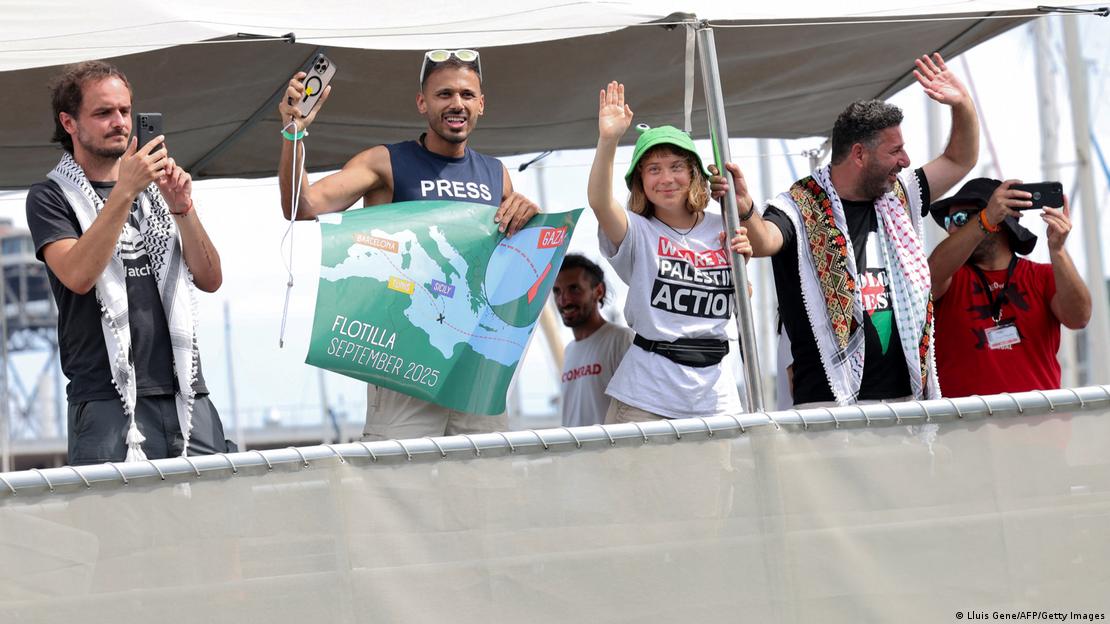 Greta Thunberg ve diğer aktivistler filo yola çıkmadan önce Barselona'da kameralara el sallıyor.