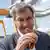 Markus Söder posing with a sausage in a breadroll