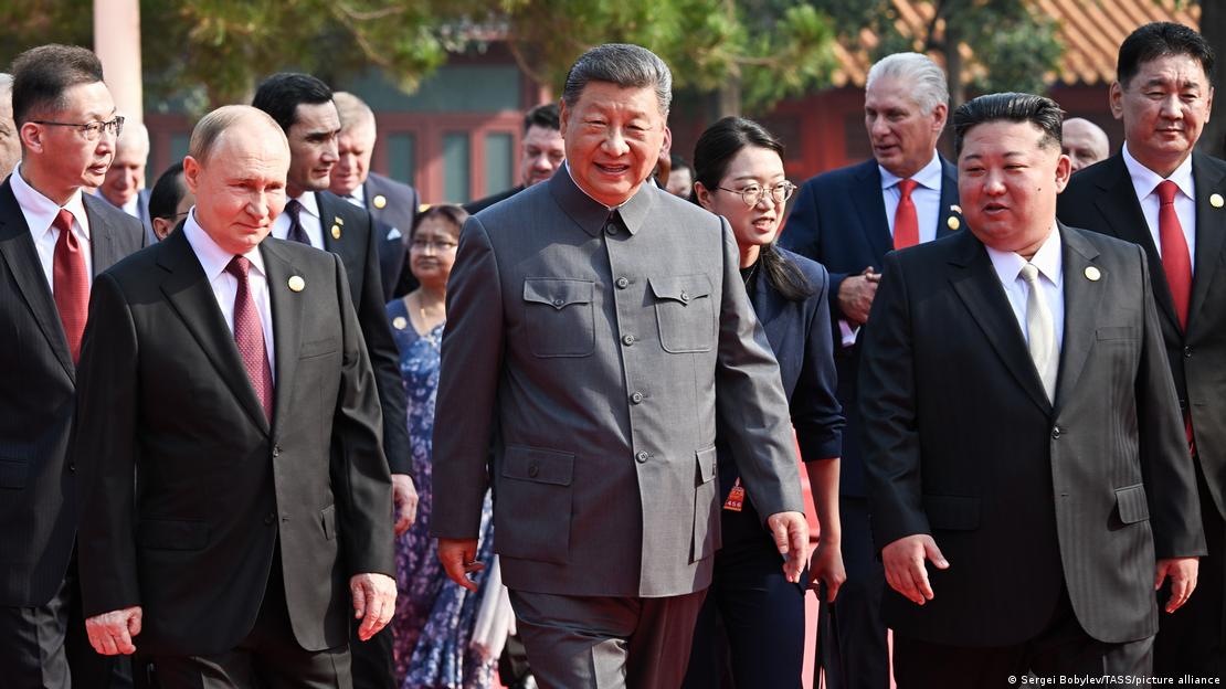 Putin, Xi y Kim en Pekín, caminando juntos, con Xi en el centro, Putin a la izquierda, y Kim a la derecha.