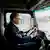 Umweltminister Carsten Schneider besucht Daimler Truck Werk - Mann sitzt am Steuer eines E-LKW