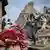 Afghan men walk on the rubble of a damaged house following a deadly magnitude-6 earthquake that struck Afghanistan on Sunday