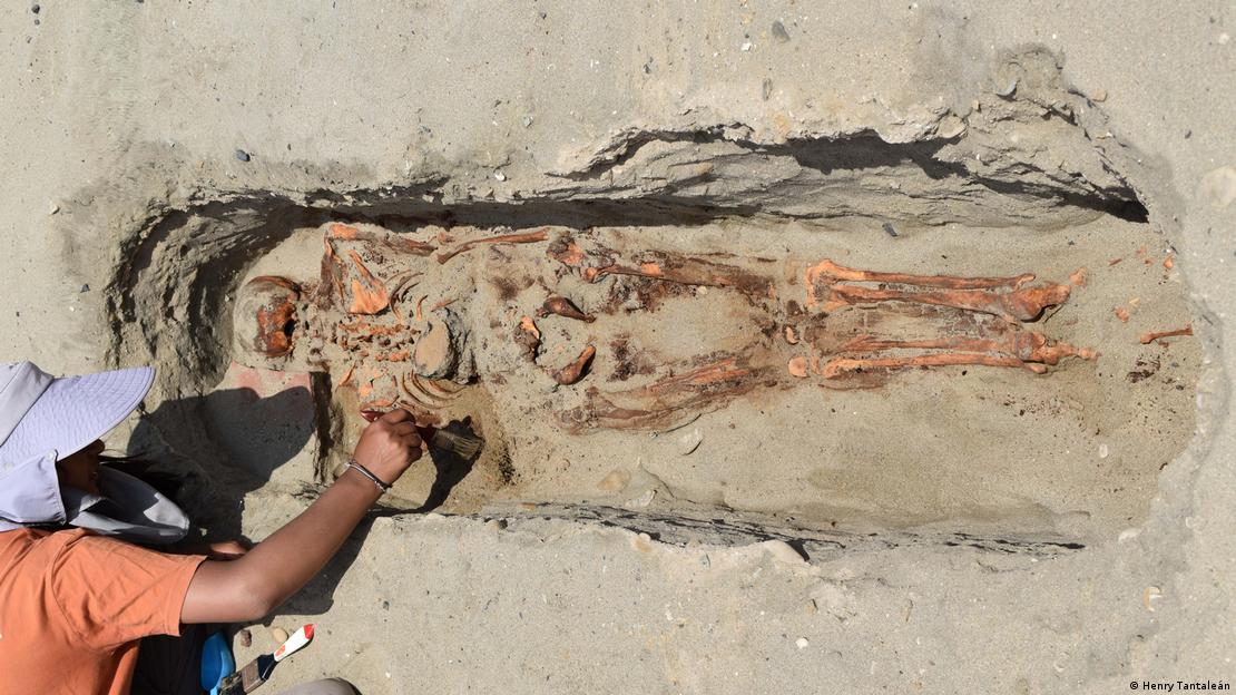 Arqueólogo estudia uno de los cuerpos hallados en el sitio arqueológico de Puémape. 