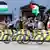 Vuelta a España 2025 | Etapa 13 | Ciclistas pasan junto a manifestantes con banderas palestinas.