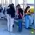 Agentes de policía registran a trabajadores de la planta, con las manos esposadas detrás (y las caras difuminadas en la imagen).