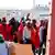 Ein Gruppe Männer auf einem Hafen, die meisten sind in orangefarbene Decken gehüllt