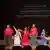 Un grupo de mujeres mexicanas canta sobre el escenario de Palacio de Bellas Artes.