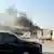 Smoke billowing after explosions in Doha's capital Qatar with black cars parked in the front