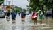 People carrying their belongings wade through a flooded street following overnight heavy rains People carrying their belongings wade through a flooded street following overnight heavy rains