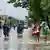 People carrying their belongings wade through a flooded street following overnight heavy rains