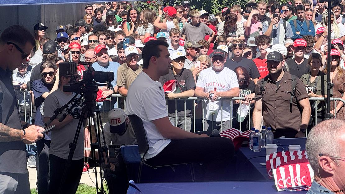 Kirk fala a uma plateia em dia ensolarado 