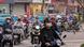 Pengendara motor di Vietnam berkendara dalam lalu lintas yang padat. Pengendara motor di Vietnam berkendara dalam lalu lintas yang padat.