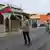 Venezuela Valencia'da elinde Venezuela bayrağı olan biri ve arkasında askeri kıyafetli siviller