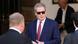 Scott Bessent, con gafas de sol y traje, con dos hombres que están de espaldas. Scott Bessent, con gafas de sol y traje, con dos hombres que están de espaldas.