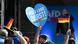 A hand holding up a sign that reads "Unser Land zuerst", or our country first, at an AfD election event. Other people wave small German flags and a stage with a speaker is seen in the background A hand holding up a sign that reads "Unser Land zuerst", or our country first, at an AfD election event. Other people wave small German flags and a stage with a speaker is seen in the background