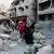 Palestinians in Gaza walk over rubble 