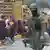 La imagen muestra en primer plano a un militar y al fondo a un grupo de manifestantes en Ecuador.
