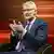 The US-correspondent of German public broadcaster ZDF, Elmar Thevessen wears a suit and gestures with his hands