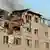 Firefighter on crane putting out fire on severely damaged building