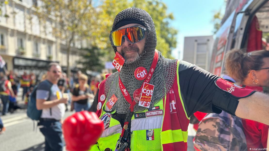 Un hombre con una cota de malla, un chaleco reflectante amarillo y unas grandes gafas de sol de espejo, Thierry Dubert, mira a la cámara.