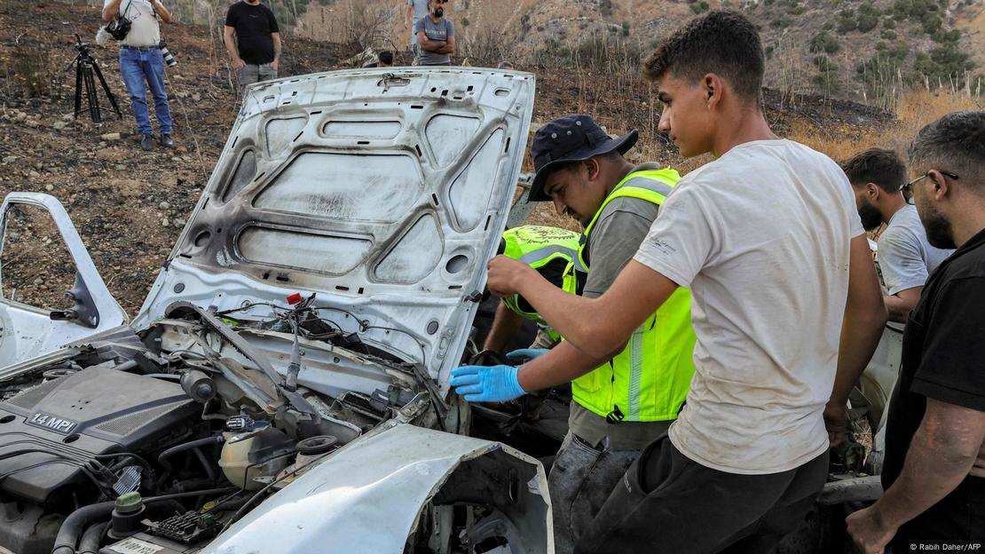 First responders and security forces' members inspect a destroyed vehicle First responders and security forces' members inspect a destroyed vehicle