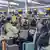 Passengers try to check their baggage in at machines in Heathrow Airport, England