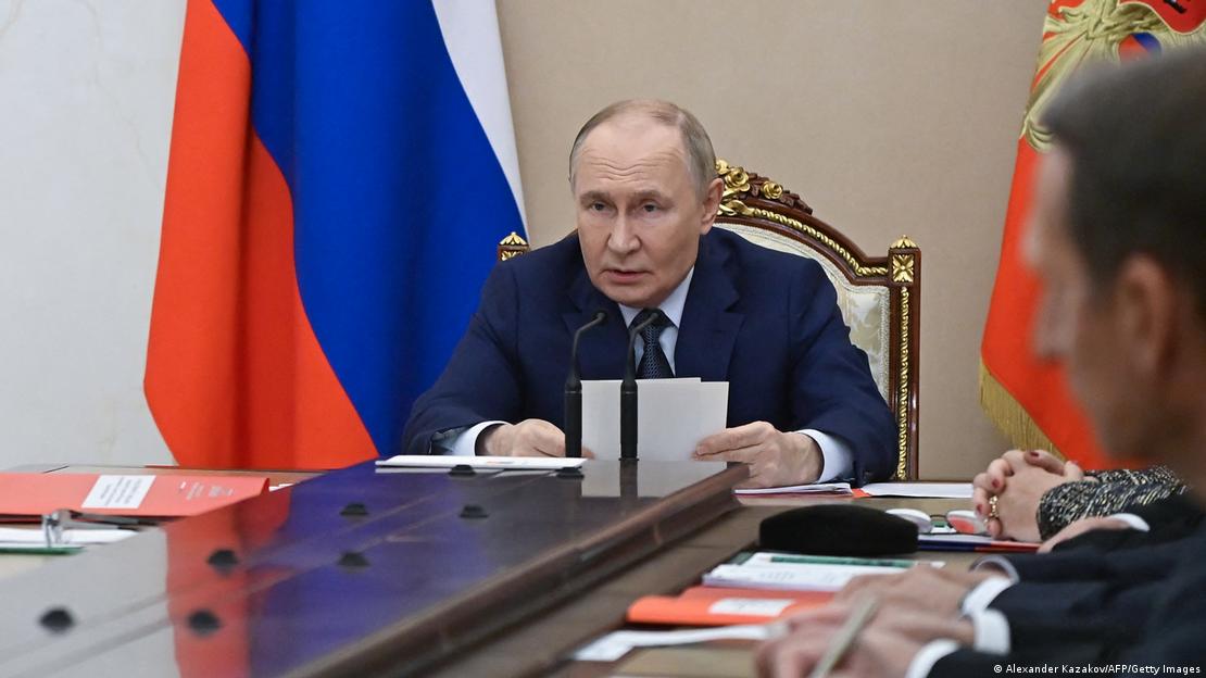 Wladimir Putin leitet am 22.9.2025 die Sitzung des Sicherheitsrates im Kreml. Er referiert an einem großen Tisch sitzend. Hinter ihm hängt eine große russische Fahne