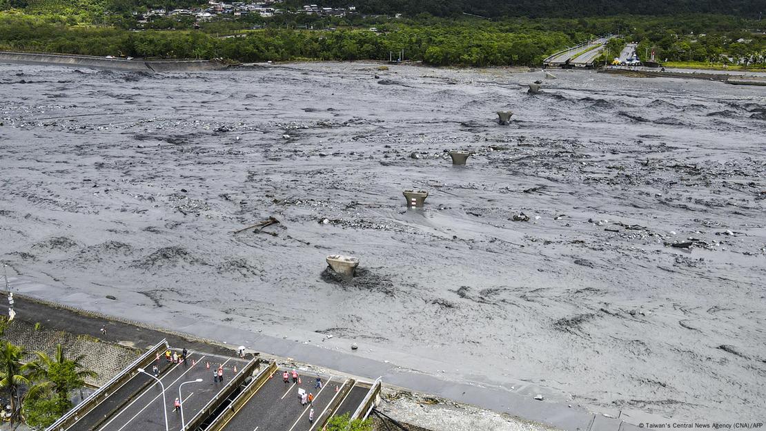 Torrentes fortes de água lamacenta passam por lugar ode uma ponte foi arrastada