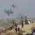 Smoke rises from an Israeli strike as displaced Palestinians fleeing northern Gaza move southward 