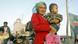 Mulher da etnia uigur com seu filho em Casgar, na região de Xinjiang Mulher da etnia uigur com seu filho em Casgar, na região de Xinjiang