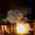 El fuego arde mientras la policía monta guardia durante una protesta de estudiantes de la Escuela Normal Rural Raúl Isidro Burgos de Ayotzinapa, con motivo del 11 aniversario de la desaparición de los 43 estudiantes, el sábado 26.09.2025.