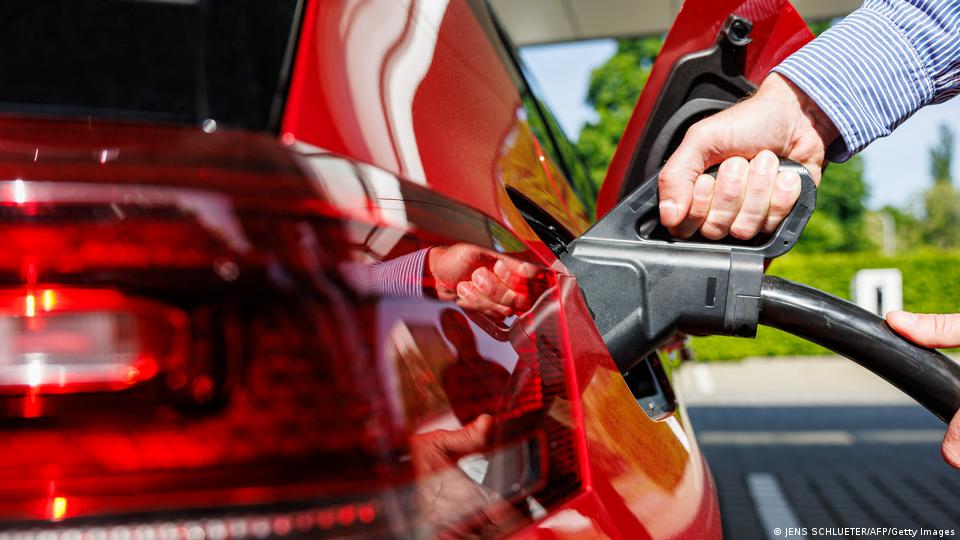 Un persona repostando gasolina en su auto.