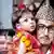 New Royal Living Goddess Aryatara Shakya face is shown beside a man who is carrying her