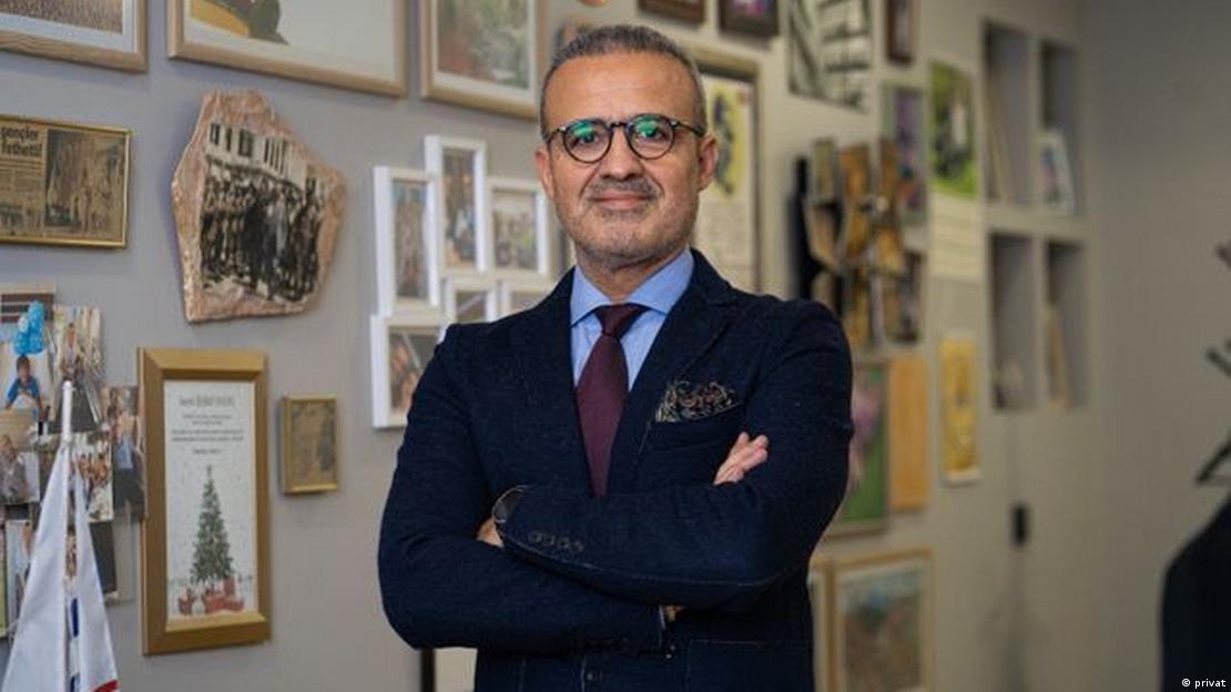 TOBB Hazır Giyim ve Konfeksiyon Sektör Meclis Başkanı Şeref Fayat iki elini birbirine bağlamış şekilde poz veriyor 