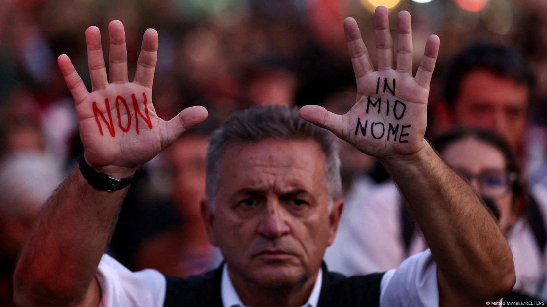 Homem ergue as mãos pintadas com as palavras "não em meu nome" em protesto pró-palestinos em Roma