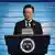 South Korean President Lee Jae Myung stands at a lecturn and looks down at a speech on October 1, 2025