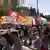 Un grupo de personas marcha por Roma con banderas y pancartas.