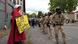 Policiais do ICE uniformizados ao lado de manifestante com cartaz Policiais do ICE uniformizados ao lado de manifestante com cartaz