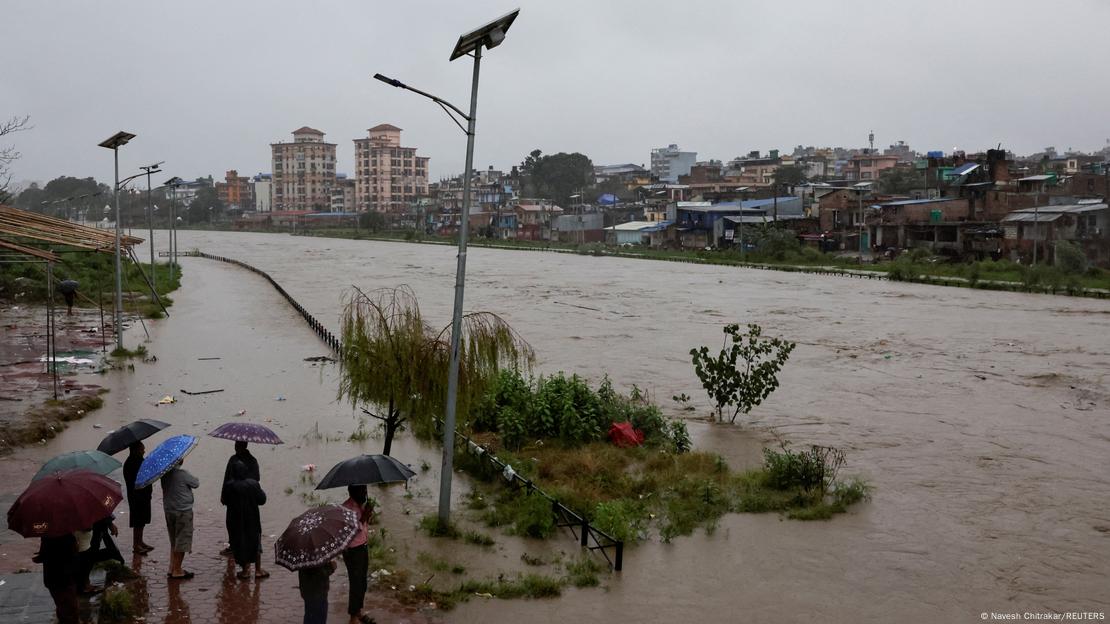 People look at the overflowing Bagmati River in Nepal
