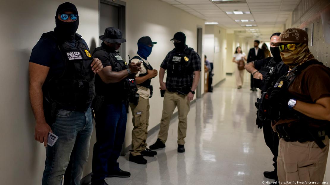 Agentes federales con los rostros ocultos patrullan los pasillos del tribunal de inmigración en un edificio federal de Nueva York. Escenas similares han ocurrido en Chicago y han derivado en la detención de decenas de migrantes que cumplían con citas de rutuna en las cortes. (12.08.2025)