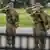 USA Washington D.C. 2025 | Nationalgardisten in Flecktarn und mit Maschinenpistolen  salutieren an einer Straße in Washington (20.09.2025)