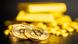 A generic picture of three bitcoin coins and gold bullion lying on a table A generic picture of three bitcoin coins and gold bullion lying on a table