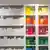 A bookshelf with white books and coloured pots and jars