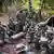 Eine Gruppe Bundeswehr-Soldaten bei der Ausbildung im Wald, im Hintergrund ein Zelt und Bäume
