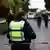 Eine Polizistin steht hinter einem rot-weißen Absperrband