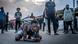 Un jeune manifestant accroupi au sol se protège de la police. Un jeune manifestant accroupi au sol se protège de la police.