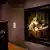 Eine Frau in einem Museum steht vor einem Rembrandt-Gemälde und schaut es sich an.